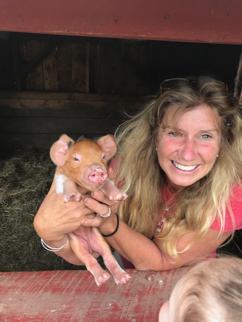 Farmer Julie holding a piglet at Flamig Farm